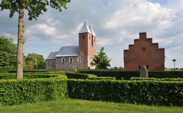 Udsigt fra mindelunden mod kirken. Genforenings-egen i forgrunden blev plantet i 1920.